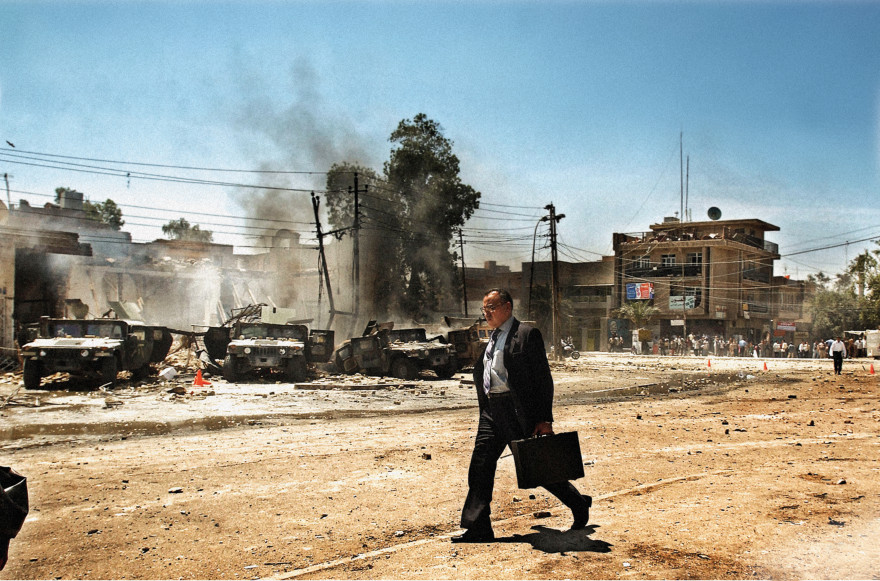 IRAQ. Baghdad, Iraq. Monday, April 26, 2004. An Iraqi man walks by the scene of an attack on US Army Humvee's that caused several American casualties in the Al-Waziriyah neighborhood of Baghdad.
