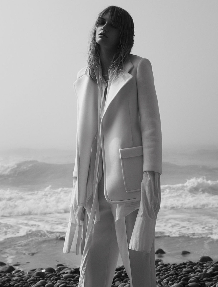 Model Yulia photographed in black and white by photographer Vera Comploj for MONROWE Magazine. White Coat and Trousers by Tamuna Ingorokva White Oversized Shirt by Daniel Gregory Natale